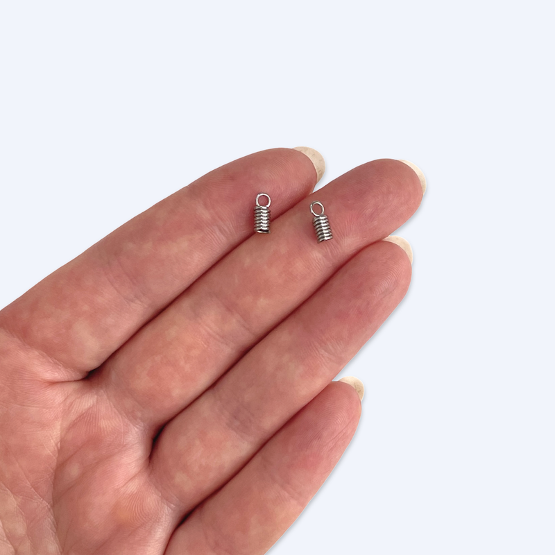 Kämmenellä pieniä spiraalimaisia nyörinpäitä koon havainnollistamiseen, 8 x 3 mm kirurginteräs