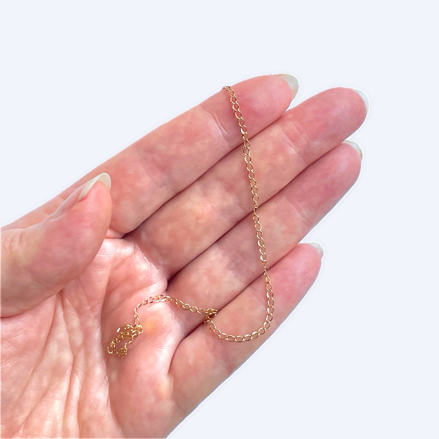 Kullattu koruketju kämmenellä havainnollistaa pituutta, 3 x 2 mm, 18K kirurginteräs