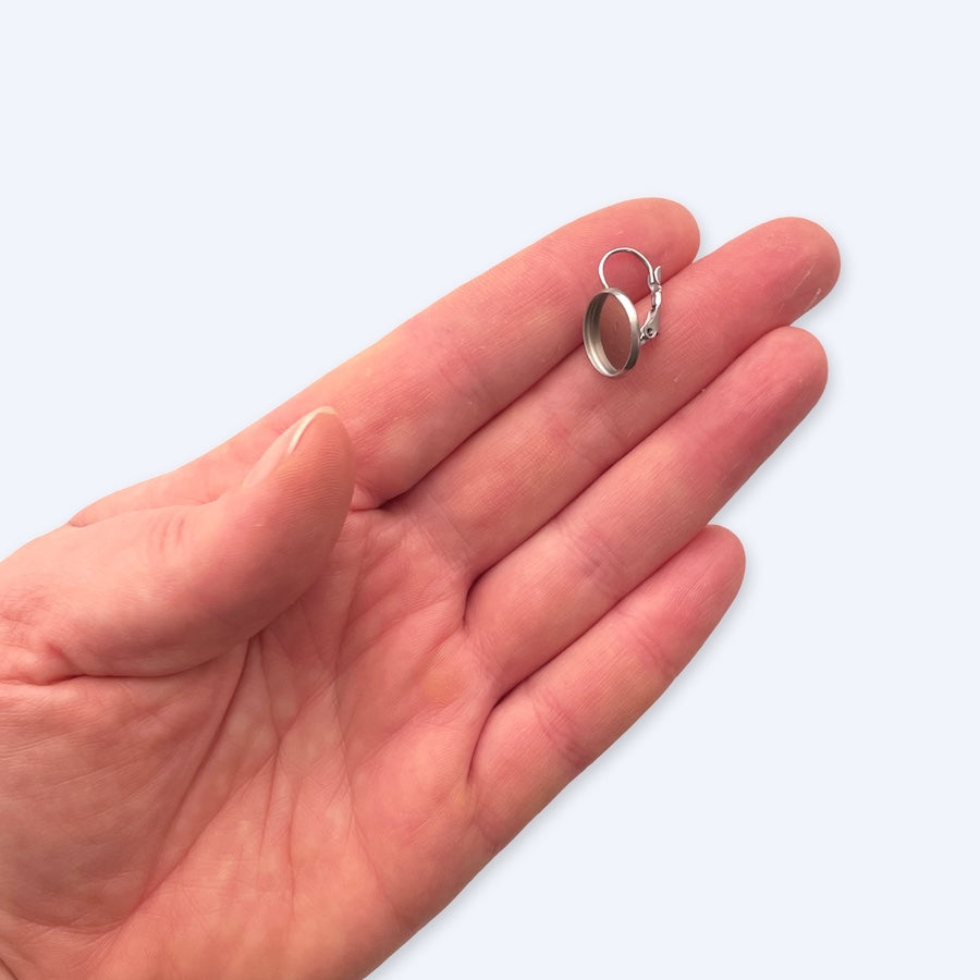 Pari lukittavia korvakorukoukkuja 12 mm kapussipohjalla, korvareikien turvaan, kirurginteräs