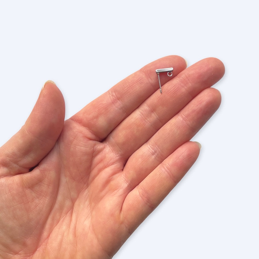 Useita 10 mm pylväällä korvakorutappeja rivissa, kirurginteräksiset korutarvikkeet
